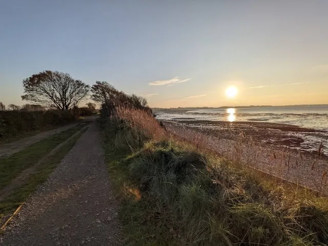 A family cycling the Hayling Billy Trail under a brick railway bridge on Hayling Island